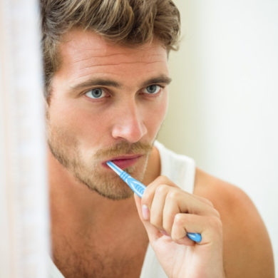reflection-young-man-brushing-teeth_107420-28909